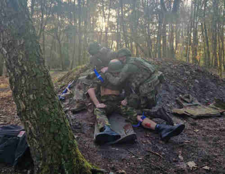 Militairen behandelen een gewonde buddy in het bos