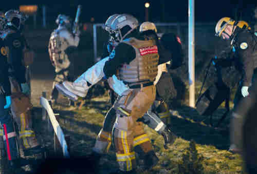 Brandweermannen dragen slachtoffer naar veiligheid
