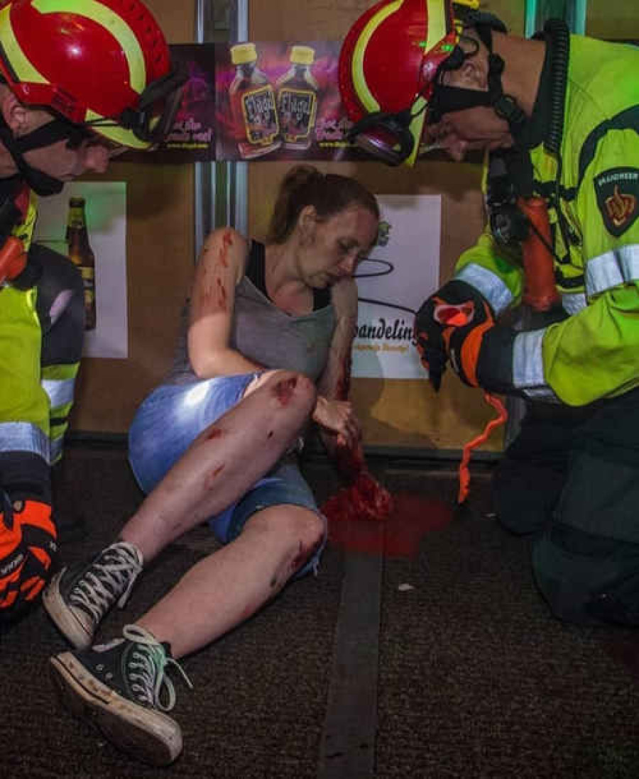 Twee brandweermannen bij een ernstig bloedend slachtoffer